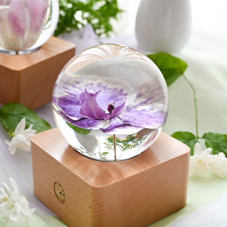 Preserved orchid flowers sealed in a clear resin sphere, still bright years later